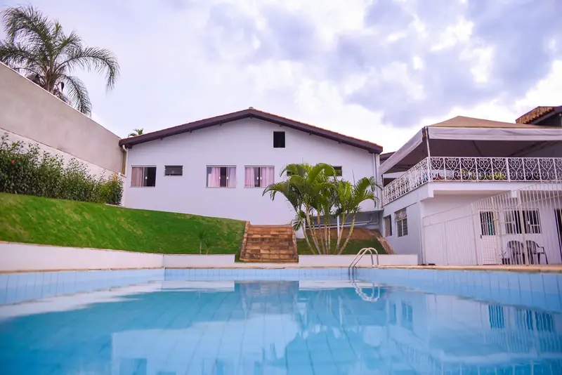 Piscina com a casa ao fundo em dia de sol